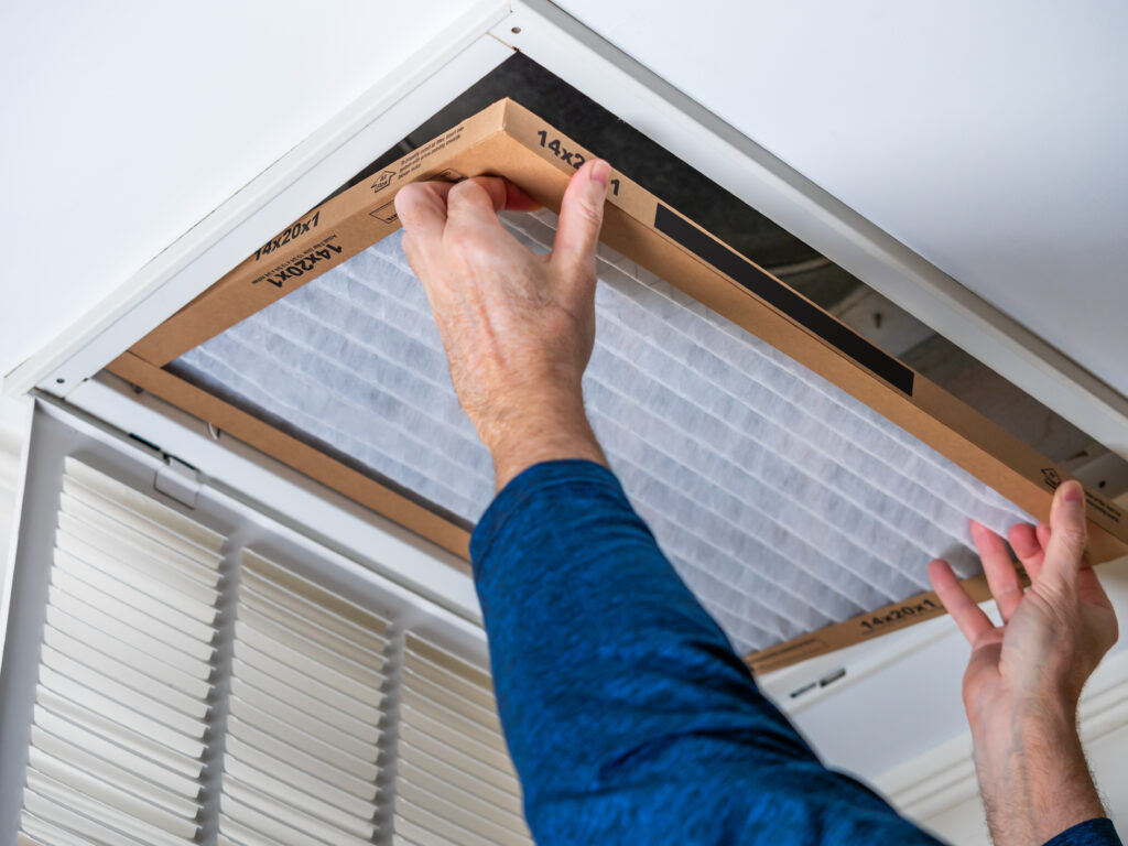 HVAC technician replacing a home air filter in San Fernando