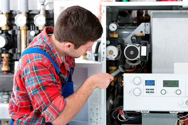 Heating technician repairing boiler controls in San Fernando