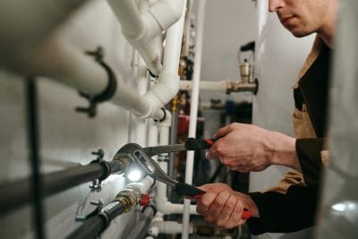 Technician inspecting commercial plumbing pipes in San Fernando