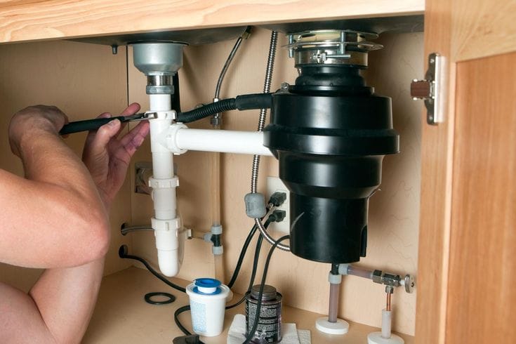 Plumber repairing a garbage disposal in San Fernando