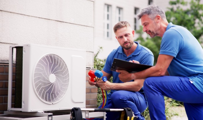 HVAC technicians installing an outdoor air conditioning unit in San Fernando
