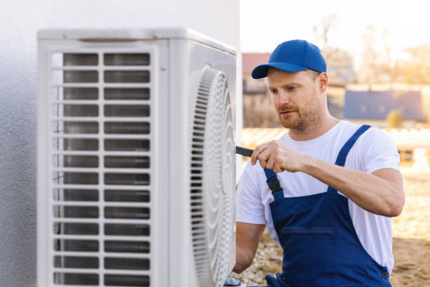 HVAC technician servicing an outdoor air conditioner in San Fernando